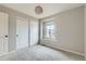 Bedroom features neutral carpet, sliding closet doors, and a window with a view at 5975 Hanover St, Denver, CO 80238