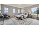Comfortable bedroom featuring a Queen bed, a bench, three windows, and a neutral color scheme at 5975 Hanover St, Denver, CO 80238