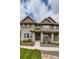 Charming home exterior with a covered porch and a beautifully landscaped front yard at 5975 Hanover St, Denver, CO 80238