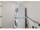 A stacked, front load, white washer and dryer set are in a well lit laundry room at 5975 Hanover St, Denver, CO 80238