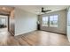 Bright living room features wood floors, a modern ceiling fan, and a pair of large windows at 5975 Hanover St, Denver, CO 80238