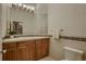 Well-lit powder room features a decorative mirror and wooden vanity with tile backsplash at 2988 Rockbridge Dr, Highlands Ranch, CO 80129