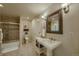 Bathroom featuring a tile shower, decorative mirror, pedestal sink, and toilet at 2988 Rockbridge Dr, Highlands Ranch, CO 80129