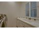 Bright laundry room area with a utility sink, counter space, window, and a modern washer/dryer set at 2988 Rockbridge Dr, Highlands Ranch, CO 80129