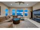 Spacious living room features a cozy fireplace, comfortable seating, and expansive windows with scenic views at 2988 Rockbridge Dr, Highlands Ranch, CO 80129