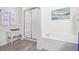 Bathroom with shower, bathtub, and updated flooring at 11261 W Quincy Pl, Littleton, CO 80127