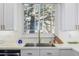 Modern kitchen sink with gold faucet and white cabinets at 11261 W Quincy Pl, Littleton, CO 80127
