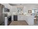 Modern kitchen with white cabinets, stainless steel appliances, and a breakfast bar at 11261 W Quincy Pl, Littleton, CO 80127
