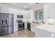 Spacious kitchen featuring stainless steel appliances and white cabinetry at 11261 W Quincy Pl, Littleton, CO 80127