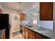 Compact kitchen area with stainless steel appliances, tile backsplash, and wooden cabinetry at 14780 E Kentucky Dr # 432, Aurora, CO 80012