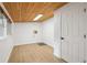 Finished basement with wood plank ceiling, clean white walls, and wood-look flooring at 5515 Dudley Ct, Arvada, CO 80002