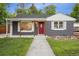 Charming single-story home with gray brick, a red door, and a well-manicured lawn at 5515 Dudley Ct, Arvada, CO 80002