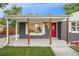 A covered front porch with wooden supports and a red door offers a welcoming entrance at 5515 Dudley Ct, Arvada, CO 80002
