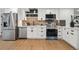 Contemporary kitchen boasting stainless steel appliances, white cabinets, and stylish backsplash at 5515 Dudley Ct, Arvada, CO 80002