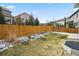 Fenced backyard with a view of neighboring houses and a partially snow-covered lawn at 3980 Trail Stone Cir, Castle Rock, CO 80108