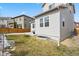 Grassy backyard with a wood fence, the house's light-colored exterior, and a concrete patio space at 3980 Trail Stone Cir, Castle Rock, CO 80108