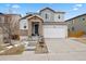 Charming two-story home featuring stone accents, gray siding, concrete driveway, and attached two-car garage at 3980 Trail Stone Cir, Castle Rock, CO 80108