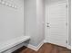 The mud room features a bench, coat hooks, wood flooring and an exterior door at 3980 Trail Stone Cir, Castle Rock, CO 80108