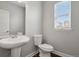 This half bath features a pedestal sink, wood-look flooring, and natural light from a window at 3980 Trail Stone Cir, Castle Rock, CO 80108