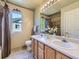 Well-lit bathroom with a dual sink vanity, tiled floors, and a window above the toilet for natural light at 10904 Eagle Run Dr, Parker, CO 80138