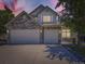 Beautiful home exterior boasts a stone facade, attached three-car garage, and manicured landscaping at dusk at 10904 Eagle Run Dr, Parker, CO 80138