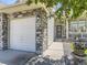 Close up exterior featuring a stone accent wall, three-car garage, and covered entry way at 10904 Eagle Run Dr, Parker, CO 80138