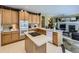 Spacious kitchen featuring an island cooktop, light wood cabinets, and a view of the fireplace at 10904 Eagle Run Dr, Parker, CO 80138