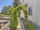 Charming walkway beside house features lush vines growing over an archway, and garden beds with flowers at 10904 Eagle Run Dr, Parker, CO 80138
