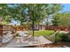 Landscaped backyard with a hammock, patio area, and a charming garden shed surrounded by lush greenery at 2740 N Fillmore St, Denver, CO 80205