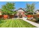 Spacious backyard with a well-maintained lawn, patio furniture, and a charming brick house at 2740 N Fillmore St, Denver, CO 80205