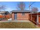 View of the detached garage with brick and concrete exterior and a gray door under a blue sky at 2740 N Fillmore St, Denver, CO 80205