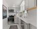 Modern kitchen with white cabinets, stainless steel appliances, and herringbone backsplash at 2740 N Fillmore St, Denver, CO 80205