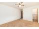 A bedroom featuring neutral carpet, a ceiling fan, closet, and a peek into the bathroom at 5582 E Colorado Ave, Denver, CO 80222