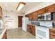 Traditional kitchen featuring wood cabinets, white appliances, and neutral countertops at 5582 E Colorado Ave, Denver, CO 80222