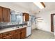 Cozy kitchen with wood cabinets, stainless sink, and classic patterned wallpaper at 5582 E Colorado Ave, Denver, CO 80222
