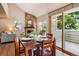 Dining area features wood table for four, with sliding glass doors to a small patio, and wood flooring at 1310 S Monaco Pkwy # 23, Denver, CO 80224