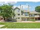 Charming multi-story exterior showcasing a well-maintained lawn, mature tree, and green siding at 1310 S Monaco Pkwy # 23, Denver, CO 80224