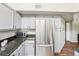 Bright kitchen features stainless steel refrigerator and gray cabinets at 1310 S Monaco Pkwy # 23, Denver, CO 80224