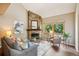 Comfortable living room with a stone fireplace, large window with natural light, and neutral-toned furniture at 1310 S Monaco Pkwy # 23, Denver, CO 80224