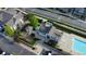 Aerial view featuring a community pool, clubhouse, playground, and ample parking surrounded by lush greenery and manicured lawns at 23560 Alamo Pl # B, Aurora, CO 80016