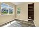 Bedroom with two windows, wood-look flooring, and a built-in bookcase at 23560 Alamo Pl # B, Aurora, CO 80016