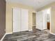 Bedroom featuring wood-look floors, double closet doors, and access to the bathroom at 23560 Alamo Pl # B, Aurora, CO 80016