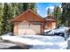 Spacious detached garage with ample parking and storage in a serene, snowy setting near evergreen trees at 21221 Colorado 103, Idaho Springs, CO 80452