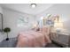 Bedroom with pink bedding and window views at 45032 Sunflower Ln, Bennett, CO 80102