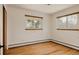 Light and airy bedroom featuring two windows and hardwood flooring at 5700 E Floyd Ave, Denver, CO 80222