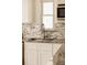 Granite countertop and stylish tile backsplash with a modern stainless steel sink at 5700 E Floyd Ave, Denver, CO 80222