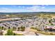 Wide aerial view of a commercial shopping area with extensive parking and nearby residential homes at 1232 Berganot Trl, Castle Pines, CO 80108