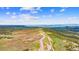 Large lot with rolling hills and a private road leading through the countryside at 1232 Berganot Trl, Castle Pines, CO 80108