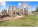 Spacious backyard featuring a manicured lawn, patio area, mature trees, and a privacy fence, ideal for outdoor enjoyment at 1232 Berganot Trl, Castle Pines, CO 80108