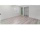 Unfurnished bedroom boasts a closet, basement window, light gray walls, and light hardwood floors at 1232 Berganot Trl, Castle Pines, CO 80108